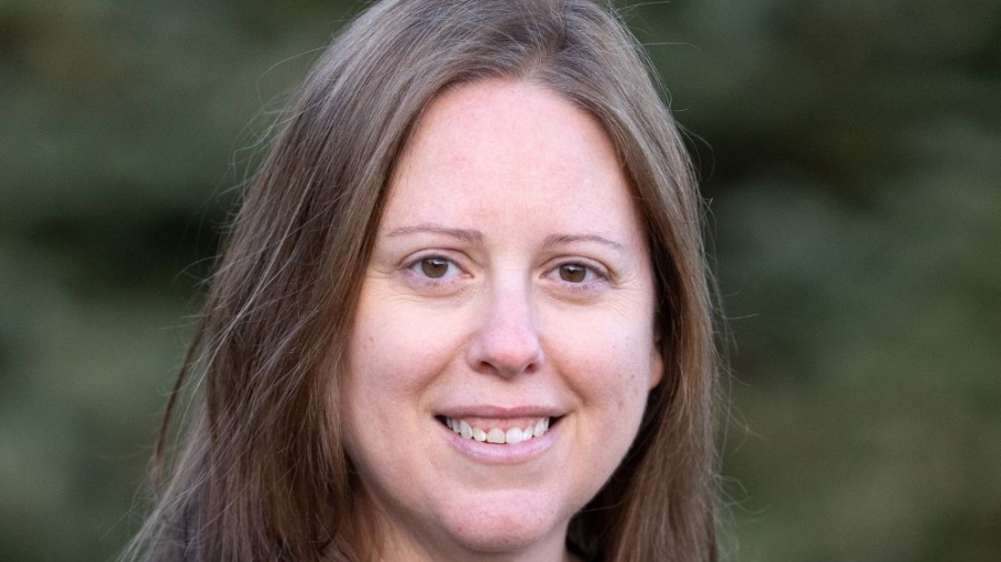 White woman with long hair with trees in the background