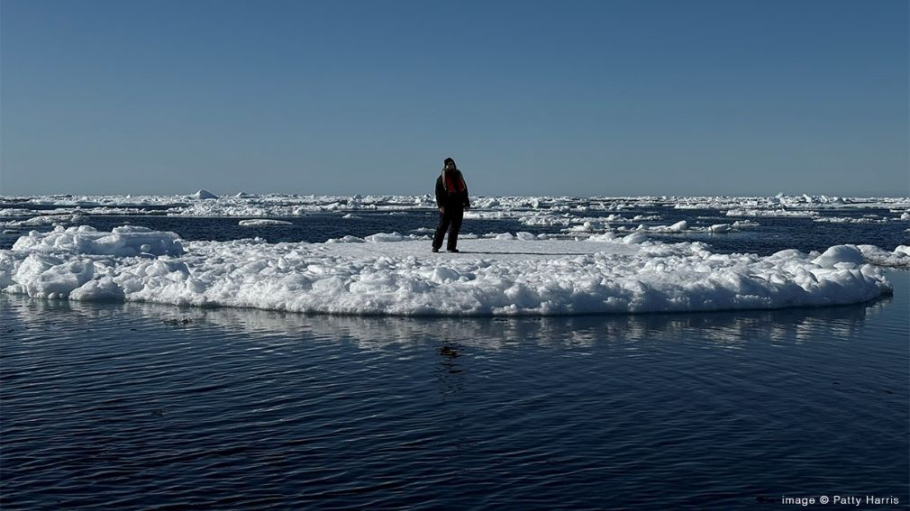 Woman bundled in winter coat and hood standing on an ice flow