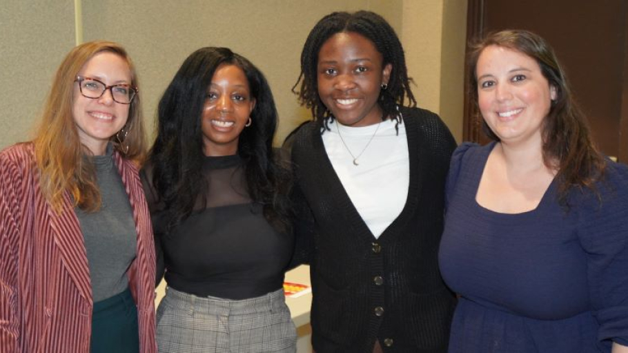 Four women in professional dress pose
