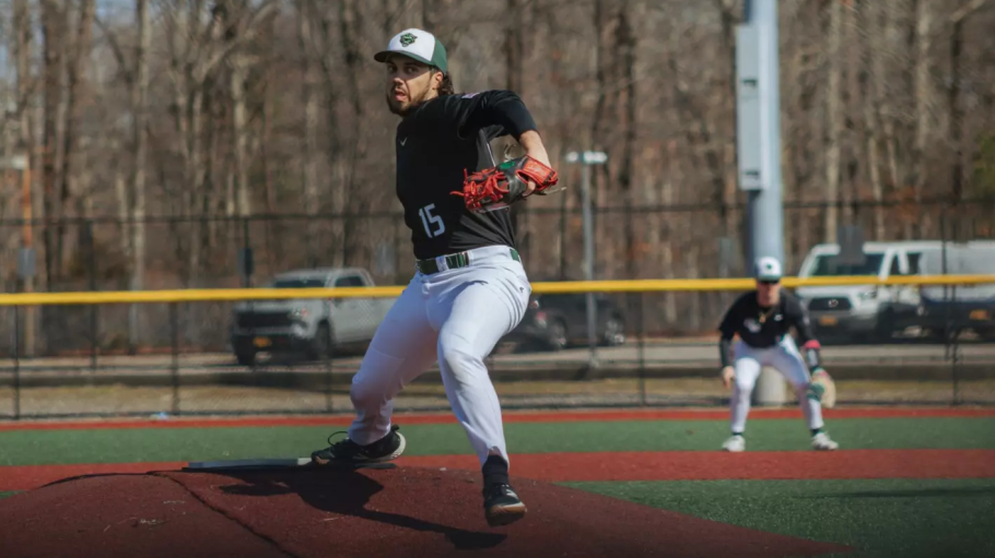 Athlete wearing green and white uniform throws from a pitcher's mound