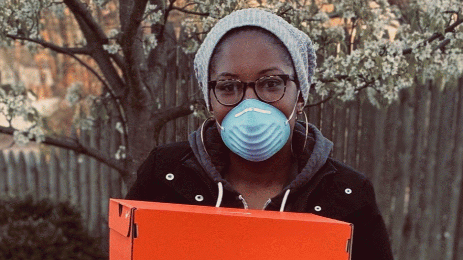 Ajon Crump poses with boxed Nikes she is giving to nurses