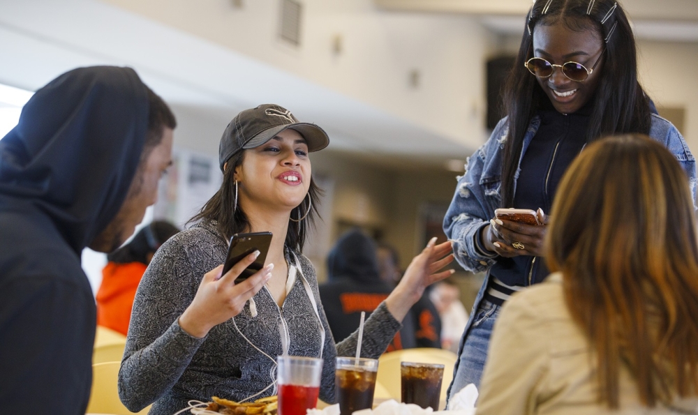 Four student laughing in the dining hall