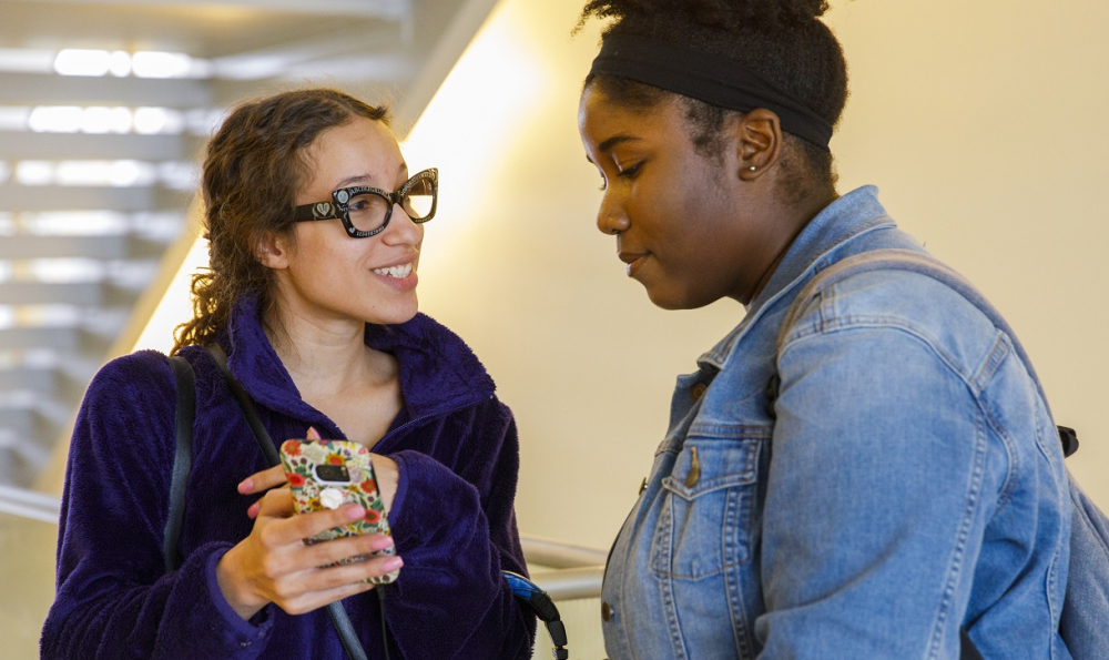 Two students looking at a mobile phone together