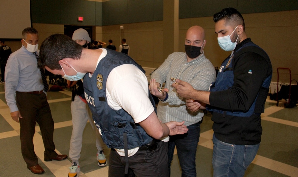 IRS Agent shows a student how to apply handcuffs during Adrian Project