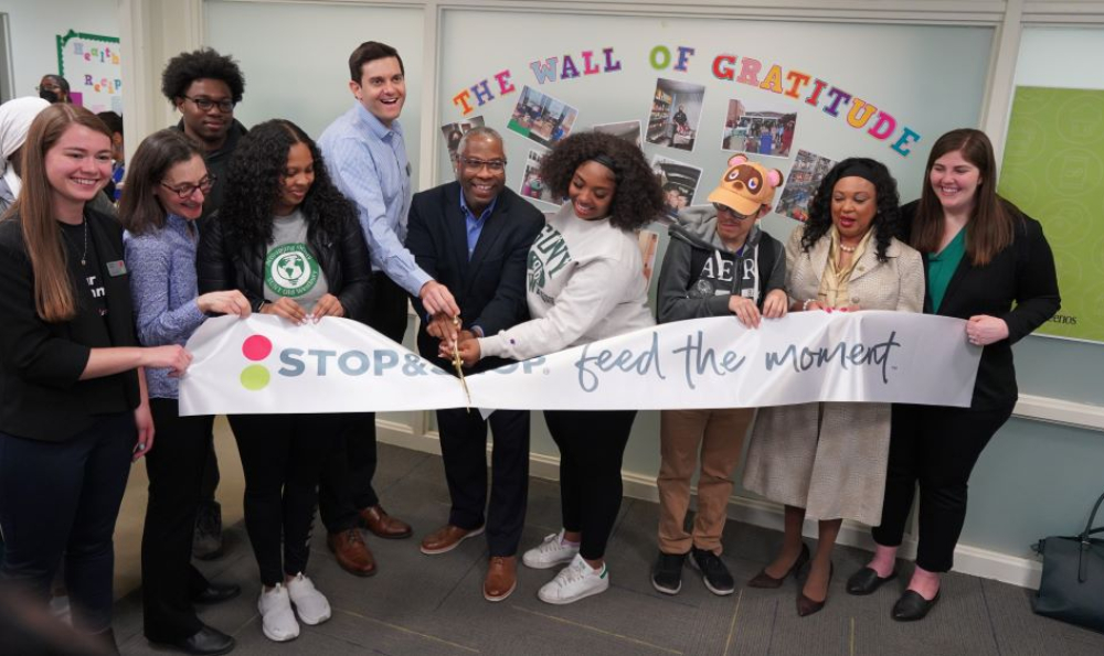 Ten people take part in a ceremonial ribbon cutting in the Panther Pantry