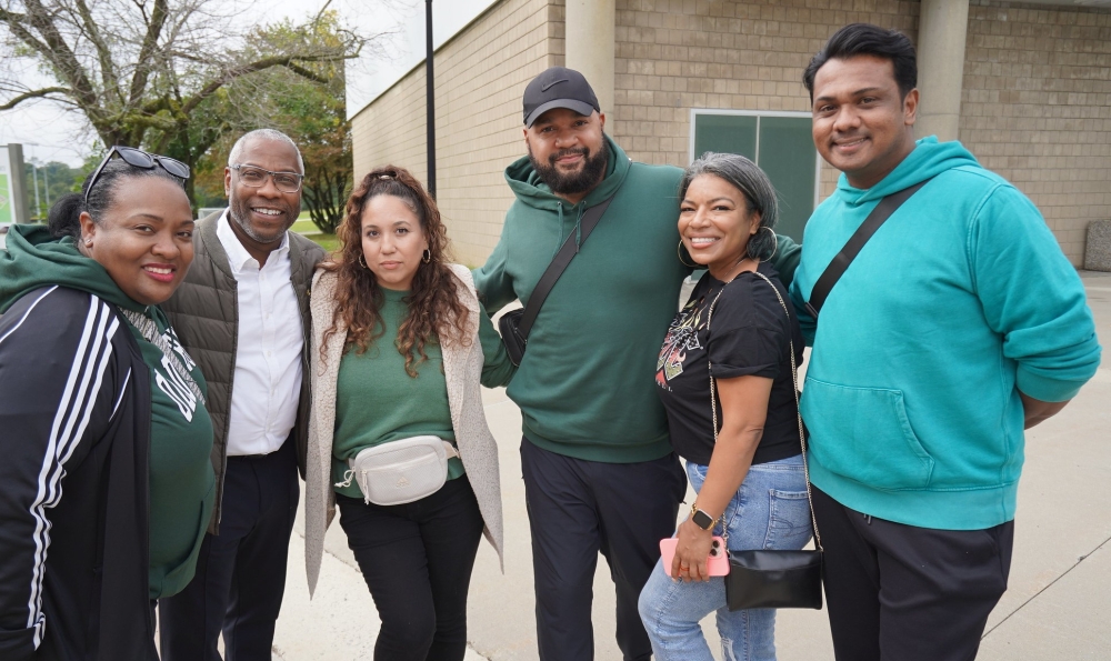 Five alumni with President Sams outside the Clark Center