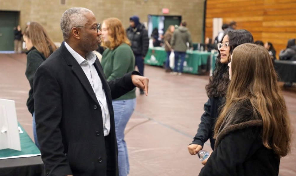 African American man talking with two young women