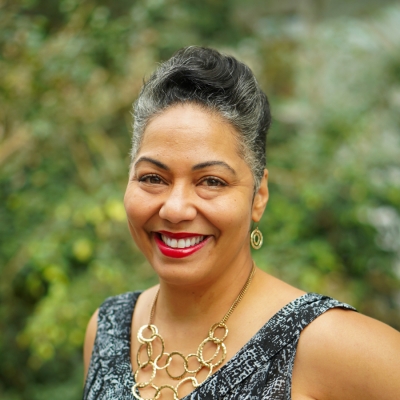 Headshot of  Lisandra Ramos in a Black and Grey shirt