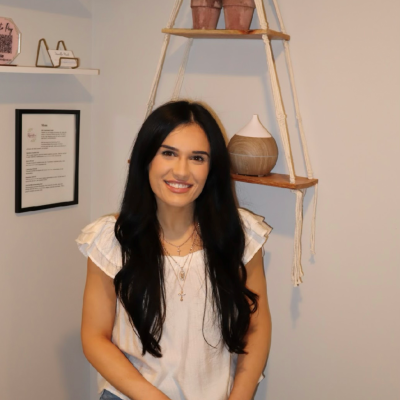 woman poses in front of wall