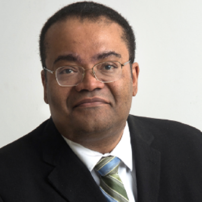 African American man with glasses in a black suit with a silver tie